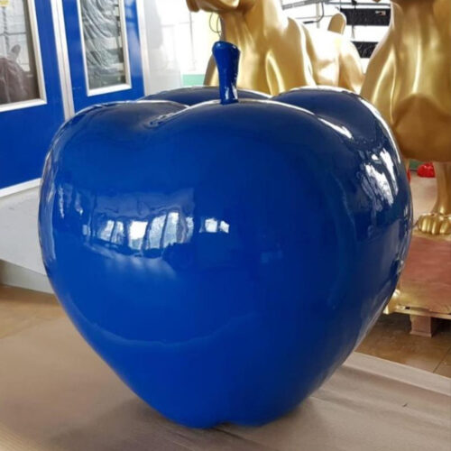 Błyszczące, intensywnie niebieskie jabłko ceramiczne na jasnym tle