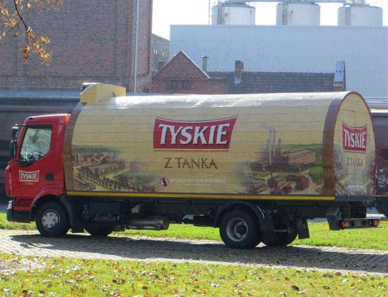 Mobile Werbung - TYSKIE mit TANKA 2 Ciężarówka marki Tyskie z beczką w tle budynków browaru.