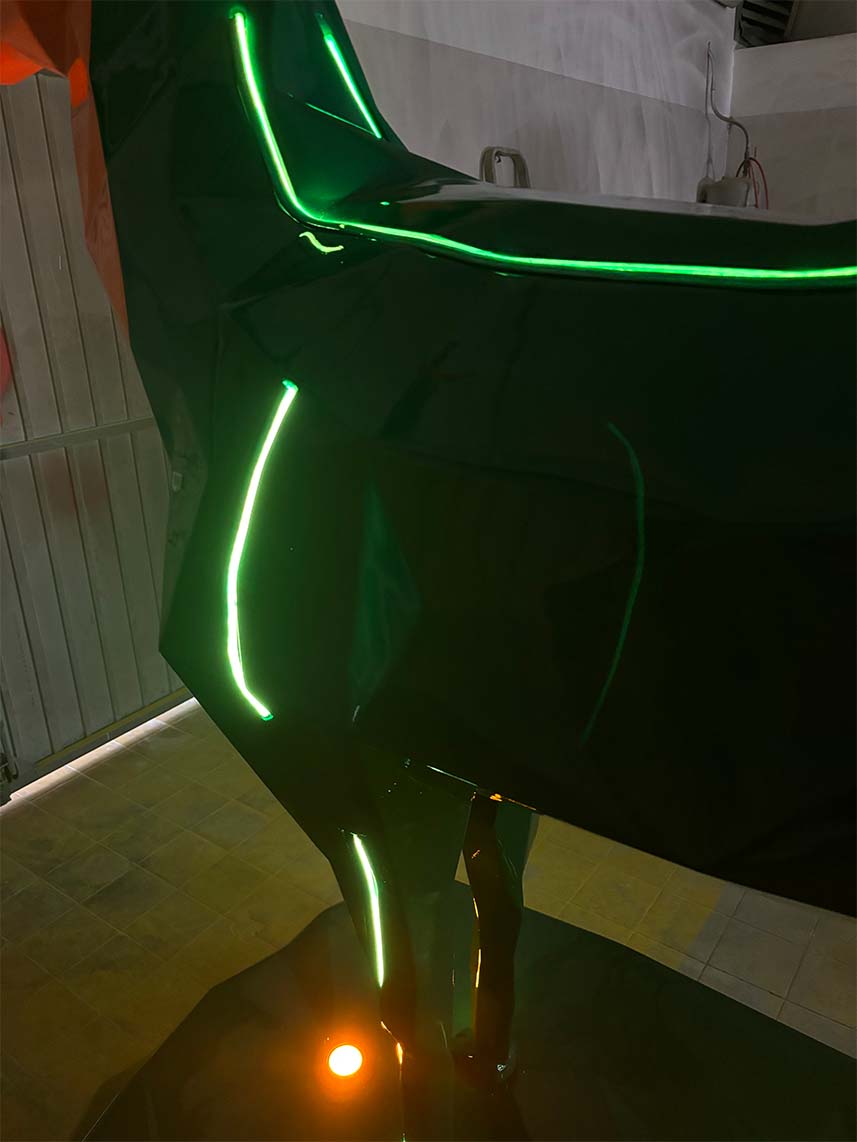 Jägermeister-Hirsche mit LED-Beleuchtung 5 Zdjęcie przedstawia ciemny obiekt o błyszczącej powierzchni z podświetleniami w kolorze zielonym, znajdujący się w zamkniętym pomieszczeniu.