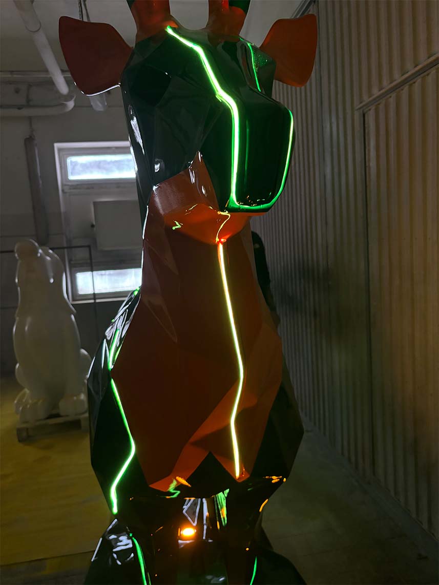 Jägermeister-Hirsche mit LED-Beleuchtung 4 Geometryczna rzeźba żyrafy z neonowymi zielonymi i pomarańczowymi światłami.