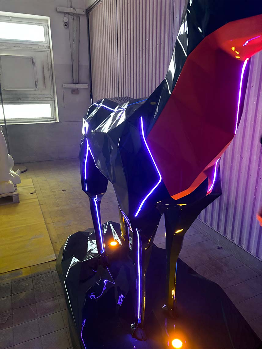 Jägermeister-Hirsche mit LED-Beleuchtung 3 Rzeźba geometrycznego zwierzęcia z neonowymi światłami w warsztacie.